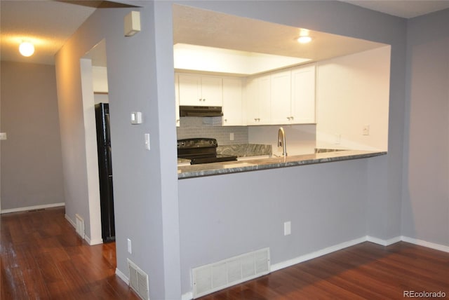 kitchen featuring white cabinetry, dark hardwood / wood-style floors, electric range, light stone countertops, and decorative backsplash