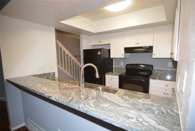 kitchen featuring tasteful backsplash, sink, light stone countertops, black appliances, and white cabinetry