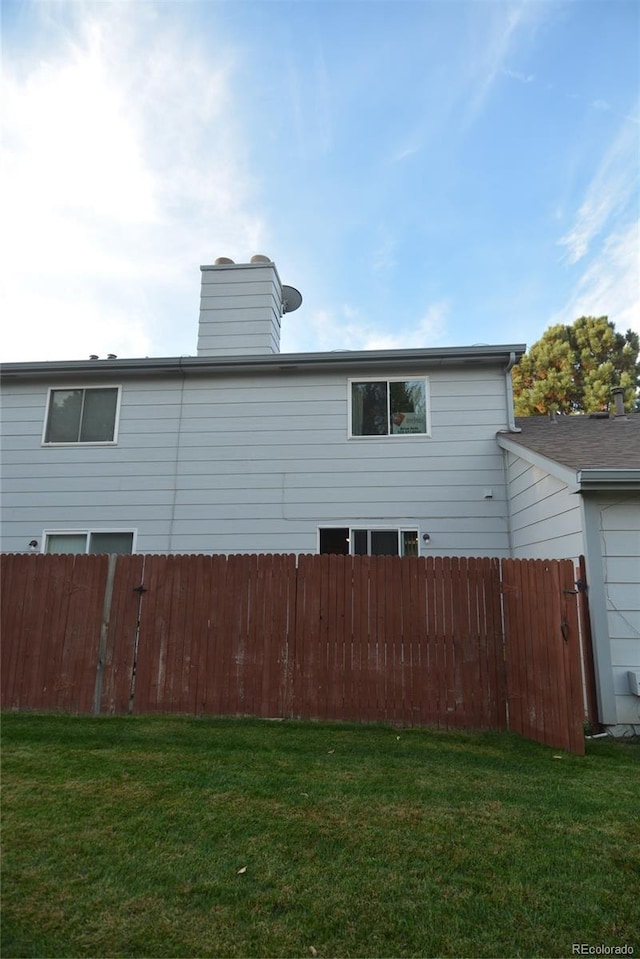 rear view of house featuring a yard