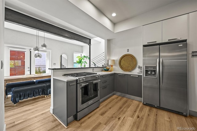 2565 Champa St, Denver, CO 80205 - kitchen featuring appliances with stainless steel finishes, gray cabinetry, a peninsula, light wood-style floors, and recessed lighting