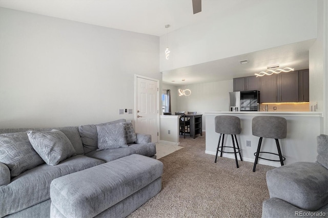 living room featuring a high ceiling and light carpet