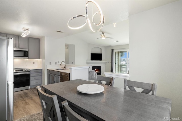 dining space with dark wood-type flooring, ceiling fan, and sink