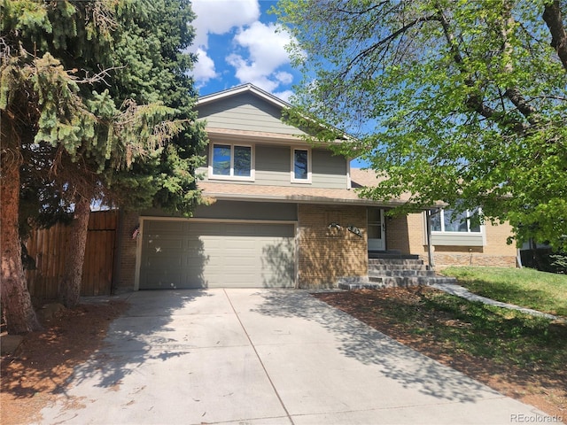 traditional-style home featuring concrete driveway, brick siding, fence, and a garage