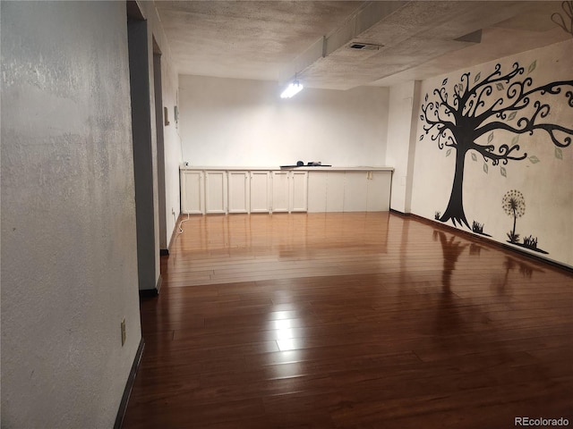 unfurnished room with wood-type flooring and visible vents