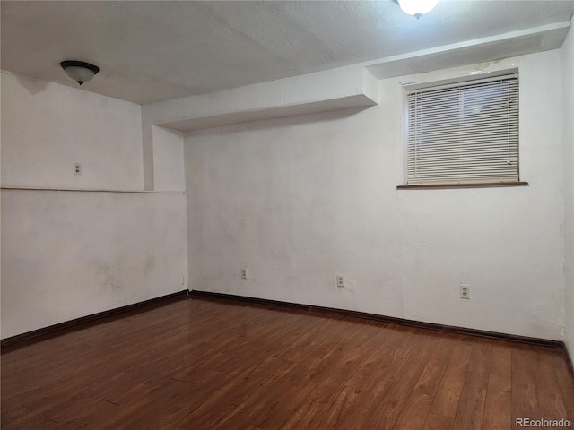 empty room featuring baseboards and wood finished floors