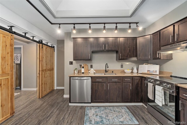 kitchen featuring dark hardwood / wood-style floors, sink, stainless steel appliances, a barn door, and dark brown cabinets