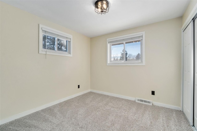 unfurnished bedroom featuring light carpet and a closet