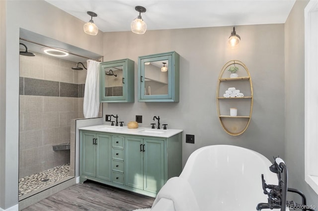 bathroom featuring hardwood / wood-style flooring, plus walk in shower, and vanity