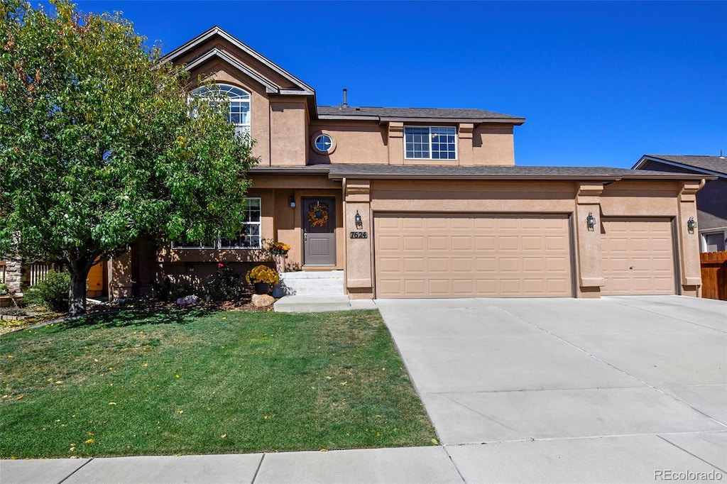 view of front of house featuring a front yard and a garage