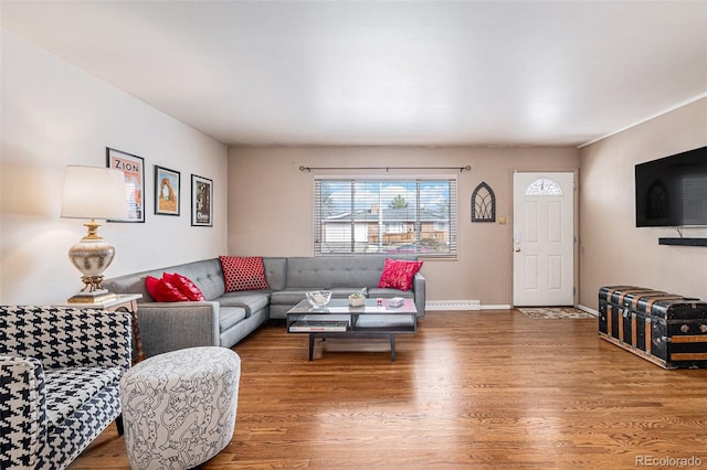 living room featuring a baseboard heating unit and hardwood / wood-style floors