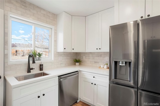 kitchen featuring decorative backsplash, white cabinetry, sink, and stainless steel appliances