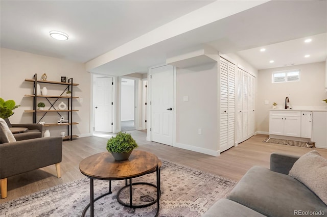 living room featuring light wood-type flooring and sink