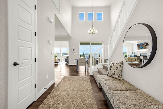 174 Rockingham Cir, Castle Pines, CO 80108 - entrance foyer with dark wood finished floors, a chandelier, stairs, and a high ceiling