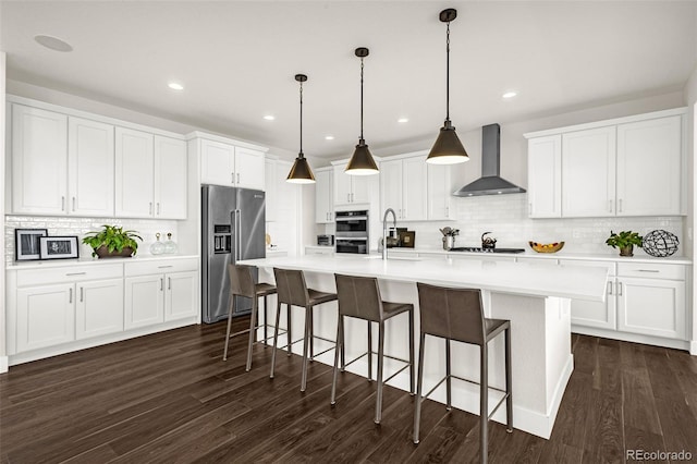 174 Rockingham Cir, Castle Pines, CO 80108 - kitchen with appliances with stainless steel finishes, wall chimney range hood, backsplash, a sink, and a center island with sink