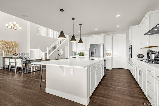 174 Rockingham Cir, Castle Pines, CO 80108 - kitchen with stainless steel appliances, dark wood-type flooring, a chandelier, white cabinets, and recessed lighting