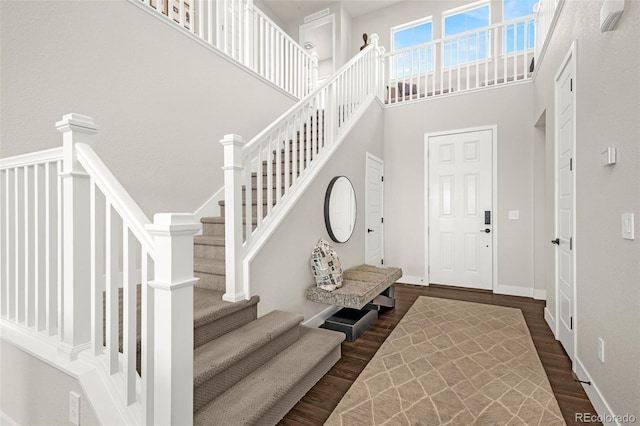 174 Rockingham Cir, Castle Pines, CO 80108 - foyer entrance with dark wood finished floors, stairs, a high ceiling, and baseboards