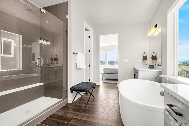 174 Rockingham Cir, Castle Pines, CO 80108 - full bath featuring connected bathroom, wood finished floors, a shower stall, vanity, and a soaking tub
