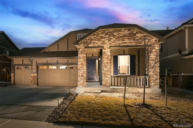 4722 S Netherland St, Centennial, CO 80015 - view of front of home with stone siding, a porch, driveway, and an attached garage