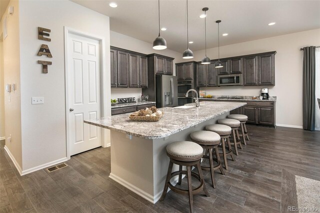 4722 S Netherland St, Centennial, CO 80015 - kitchen featuring stainless steel appliances, dark wood-type flooring, a breakfast bar, dark brown cabinetry, and recessed lighting