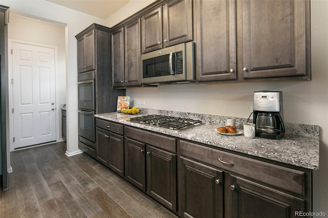 4722 S Netherland St, Centennial, CO 80015 - kitchen featuring stainless steel appliances, dark wood finished floors, dark brown cabinetry, and light stone countertops