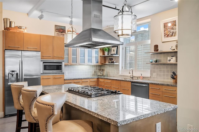 kitchen with island range hood, sink, stainless steel appliances, and decorative light fixtures