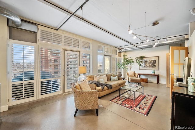 living room with concrete flooring and a healthy amount of sunlight