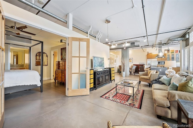 living room featuring ceiling fan and concrete flooring