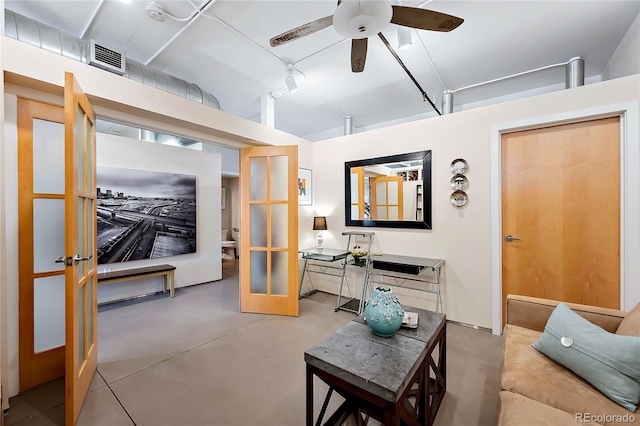 living room with concrete flooring, french doors, and ceiling fan