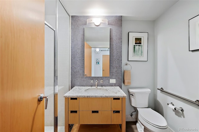 1610 Little Raven St Unit 407, Denver, CO 80202 - full bathroom featuring toilet, a stall shower, vanity, and tile walls