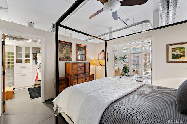 bedroom with ceiling fan and concrete flooring