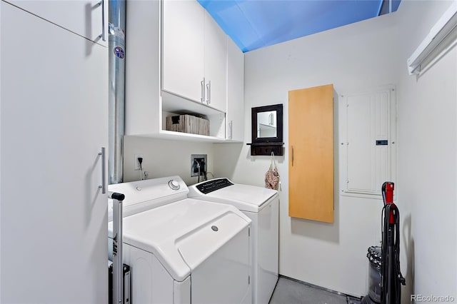 washroom featuring washing machine and clothes dryer, electric panel, and cabinets