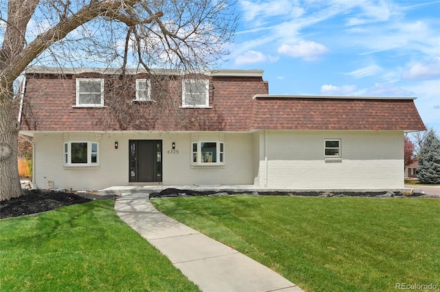 6325 W Portland Pl, Littleton, CO 80128 - view of front facade featuring brick siding, mansard roof, roof with shingles, and a front lawn