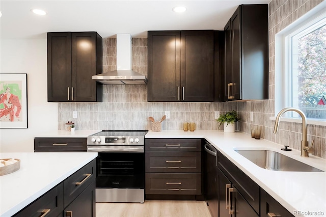 6325 W Portland Pl, Littleton, CO 80128 - kitchen featuring appliances with stainless steel finishes, a sink, wall chimney exhaust hood, light countertops, and recessed lighting