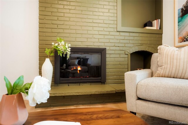 6325 W Portland Pl, Littleton, CO 80128 - sitting room featuring a brick fireplace and wood finished floors