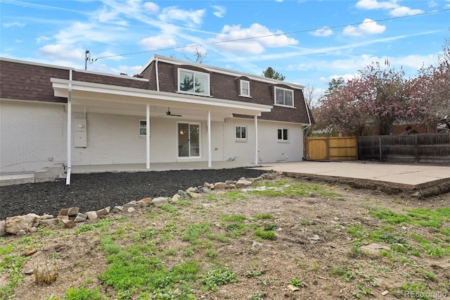 6325 W Portland Pl, Littleton, CO 80128 - rear view of house with mansard roof, a shingled roof, a patio area, and brick siding