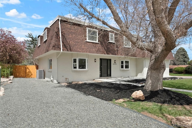 6325 W Portland Pl, Littleton, CO 80128 - view of front facade featuring brick siding, roof with shingles, mansard roof, and a patio