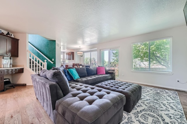 living room featuring light hardwood / wood-style floors and a textured ceiling