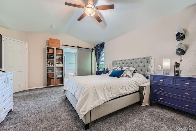 carpeted bedroom with a barn door, vaulted ceiling, and ceiling fan