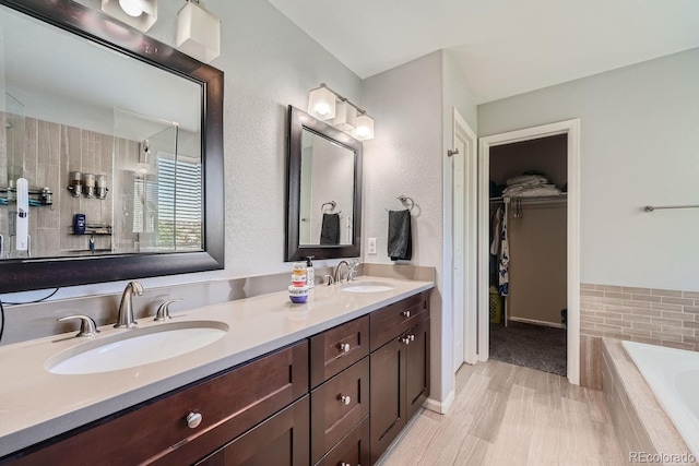 bathroom with vanity and a relaxing tiled tub