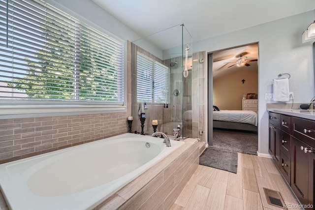 bathroom featuring plus walk in shower, vanity, and lofted ceiling