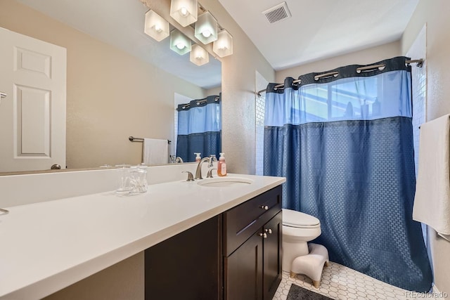 bathroom featuring tile patterned flooring, vanity, toilet, and curtained shower