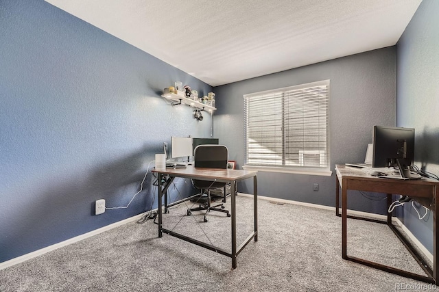 carpeted office with a textured ceiling