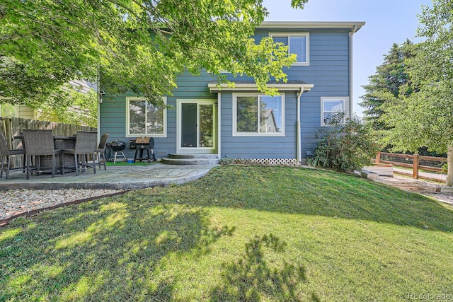 back of property featuring a patio area and a yard