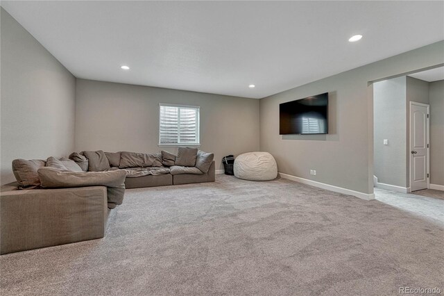 carpeted living area with baseboards and recessed lighting