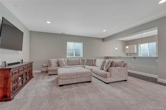 living area featuring a wealth of natural light, carpet floors, baseboards, and recessed lighting