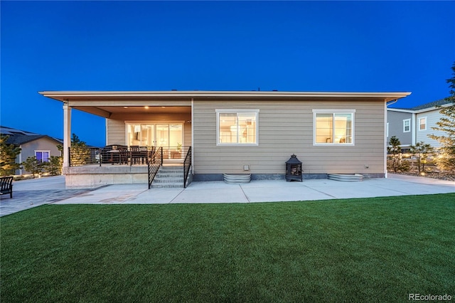 back of property featuring a patio and a lawn