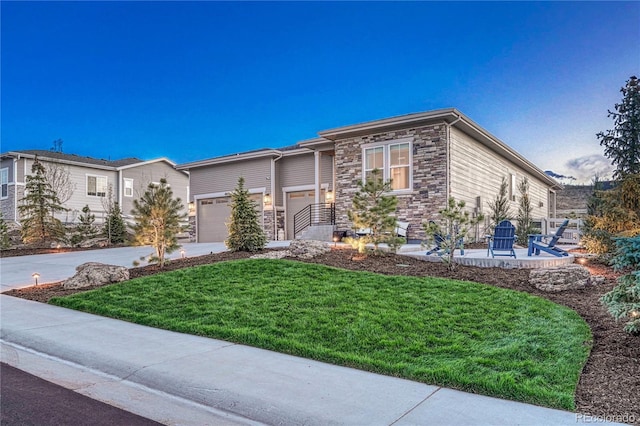 prairie-style home featuring stone siding, a front yard, and driveway