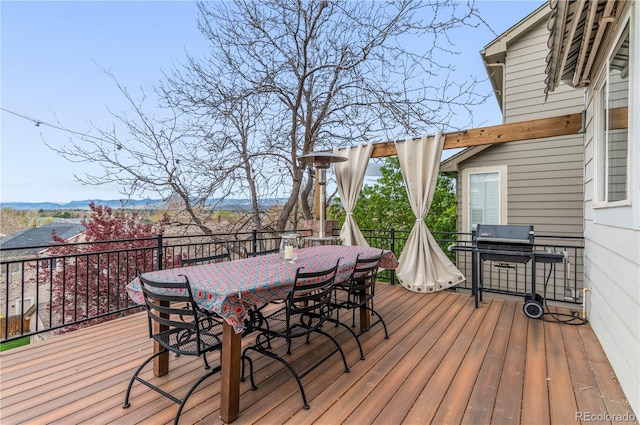wooden terrace with outdoor dining space and a grill