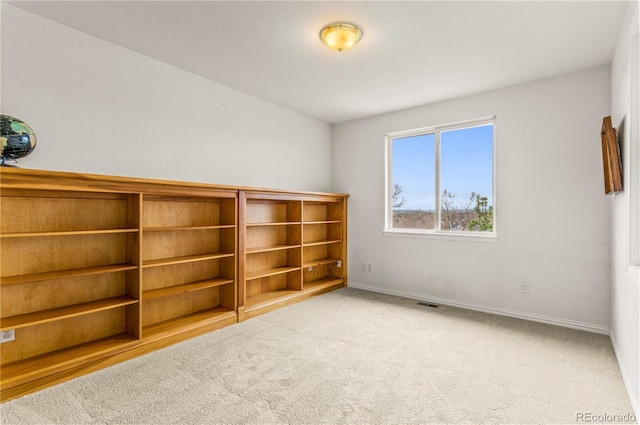 unfurnished room featuring carpet flooring and baseboards