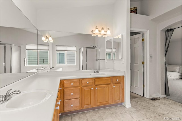 ensuite bathroom with a shower stall, tile patterned floors, a chandelier, double vanity, and lofted ceiling